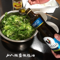 把控好的苦菊放在干净的容器中，加入一勺橄露橄榄油。