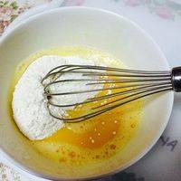 将鸡蛋打入碗里，倒入糖粉打匀，再倒入面粉和牛奶用打蛋器打匀。