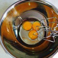 将鸡蛋的蛋黄和蛋白分离，分别放入无期无水无油的容器中，蛋黄中倒入植物油，用电动打蛋器打发至蓬松，颜色变淡。
