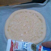在烤好的披萨胚上均匀涂一层炼奶。