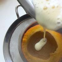 蛋液过筛倒入金瓜中，表面的气泡用汤匙舀出来；