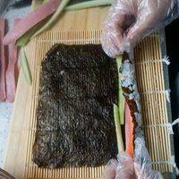 反转寿司卷，一张海苔铺好米饭后反过来放胡萝卜，黄瓜，火腿肠，同上卷紧