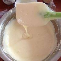 牛奶和黄油混合隔热水融化成液体后，顺着硅胶刀倒入面糊中，进行搅拌均匀后，面糊变得有光泽，拎起面糊，流动会比原先的蛋糊要快要稀一点～但是很有光泽