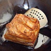 捞出肉趁热用蜂蜜和老抽各抹一遍。炒锅热油，肉皮朝下，小火煎到皮有点篷松样。注意不要被油崩到。
