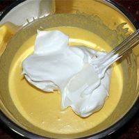 将蛋白霜加入到蛋黄糊中，以不规则的方向切拌均匀。