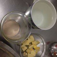黄油分小块一边待用，量杯里先放酵母，再倒入100ml30度左右温水静放5分钟。