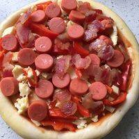 把肉类 辣椒条 芝士条均匀的铺放在披萨底上 注意芝士可以多铺一些