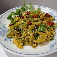 榨菜倒入盘中，放两勺芝麻油，撒少许香菜末拌匀，最后可以点缀少许辣椒圈。