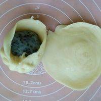 取1块静置好的面团，擀成圆形（中间厚周围薄），将1块油栗馅料放在中心，包起来。