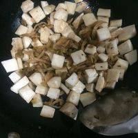另起油锅，放入鸡腿菇和榨菜翻炒，加入适量盐和糖，及鲜酱油少许，继续翻炒。