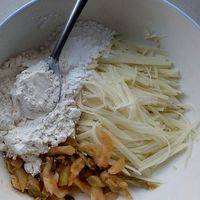 土豆切细丝，放入一个大碗，倒入榨菜，再加4勺面粉，1勺淀粉（土豆本身含有淀粉，所以不用加很多）