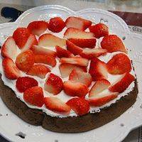 取一片蛋糕在表面涂上一层奶油，然后铺满草莓，再在草莓上抹上适量的奶油。