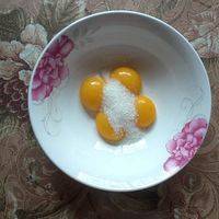 蛋黄中加入30g白糖搅拌成顺滑无颗粒蛋黄糊