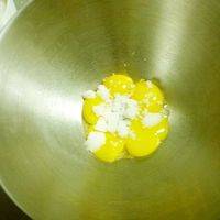 在蛋黄里加入30克白糖搅打均匀。