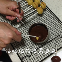 巧克力隔水熔化后，把蛋糕插入巧克力液中滚一圈，转掉多余的巧克力液。