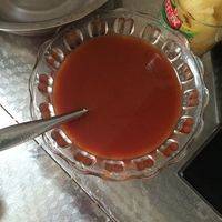 放入半袋番茄酱，然后把菠萝罐头里的糖水倒入碗里，放两小勺醋，少许白糖，搅匀备用