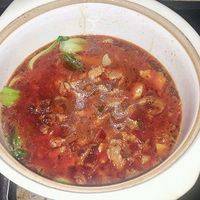 将炒好的肉片连汤汁一起倒入盛着油菜的砂锅。