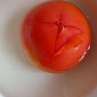 将番茄放到开水里烫一下，注意要翻动一下。烫一两分钟，在番茄的屁股上用刀轻轻画一个十。顺着十字撕开烫过的番茄皮就会很容易撕下了！