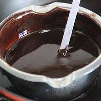 锅内的水烧热后，关火。把碗放入，轻轻搅拌至巧克力和黄油全部融化。