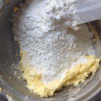 低筋面粉和玉米淀粉过筛加入到做法3的黄油里搅拌。