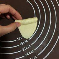 用擀面杖擀成椭圆形后由一侧卷向另外一侧