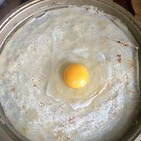 饼皮翻面，打一颗鸡蛋。用铲子摊开，均匀铺在饼皮上，加热1分钟。