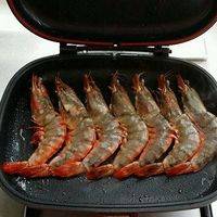 把虾放入平底锅，倒入少许油，用中火两面煎。