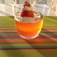把橘子QQ糖放入热水里融化，倒入已经凝固的草莓布丁上，放入冰箱冷藏。