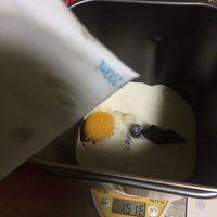 面包机桶打进全蛋一个。左上角盐右下角糖中间倒入牛奶（牛奶用冰的最好，因为温的牛奶会加速酵母过早发酵。还没扩展就发酵了那就达不到手套膜了。）