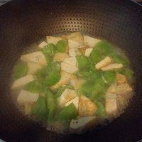 待豆腐煎得稍有黄色时下入莴苣，翻炒几下后加水焖。其间加入适量盐调味。