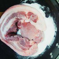 待盐的温度将至不烫手时，就把肉放入盐锅中，让肉四面都裹上盐即可。