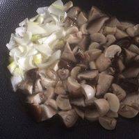 将蘑菇倒入锅中，煸炒，腾出一点位置，把葱放进去煸香。