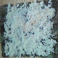 取出一片海苔，放至竹帘上，然后再均匀铺上一层薄薄的米饭，两头都空出一点，此图横着看