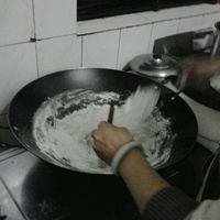 鼎里热水后倒入糯米粉，用铲子或筷子不停搅拌到熟。