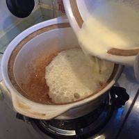 同时另外一个砂锅将淡奶油和牛奶混合加热至沸腾关火，慢慢倒入焦糖中，这是锅里会沸腾，小心溅到手。