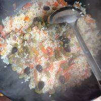 10分钟后开盖，翻一下。别胡锅。把上面的米和下面的翻动一下。放入泡好的葡萄干。