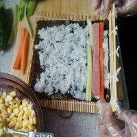 卷紫菜卷，一张海苔铺匀米饭，放黄瓜，胡萝卜，火腿，三色食材均切成长条，卷紧