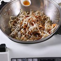 锅内倒油，放入切好胡萝卜丝、伊面、豆芽菜以及调料和水；
