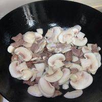 待肉变色后倒入蘑菇翻炒。