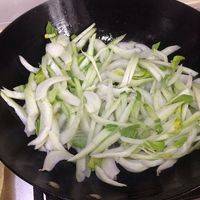 待油热后倒入青菜梗进行翻炒。