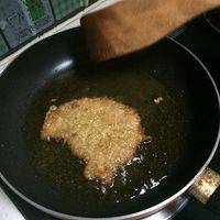 腌制好的猪排抹去姜丝蒜末，放在生粉糊里双面浸一下，迅速裹上面包糠，下油锅炸制
