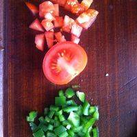 在炖煲之时、切一个带皮的番茄（为了有番茄丁状的口感）再切一些青椒丁（为了使餐品颜色漂亮）