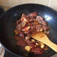 倒入牛肉和豆瓣酱，翻炒至变色。