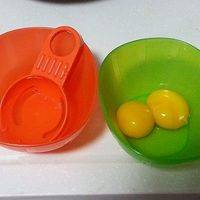 取两颗鸡蛋，用蛋黄分离器分离，蛋白可以第二天做早饭，蛋黄放入独立碗中备用。
