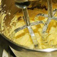 将所有粉类过筛后加入黄油浆中，手动搅拌制成面 糊；