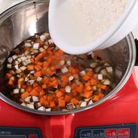 锅内倒油，放入处理好的香菇、胡萝卜、泡好的米以及水；