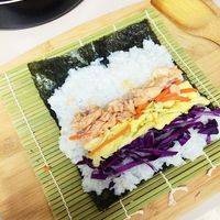 把鱼肉、蛋皮、萝卜、紫甘蓝放在米饭的一端