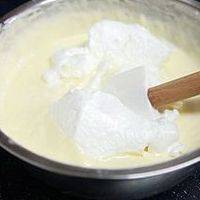 蛋白中分三次加入60克细砂糖打至弯勾状，快速将一部分蛋白放入蛋黄糊中搅拌均匀，再倒入剩余的蛋白霜中搅拌均匀。