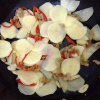 把红椒蒜末放进去炒一下，再放泡过的土豆片，翻炒