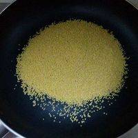 3、准备一个干净的锅（无油无水），锅烧热后放入小米，转小火翻炒至小米颜色焦黄膨胀、有米香味；